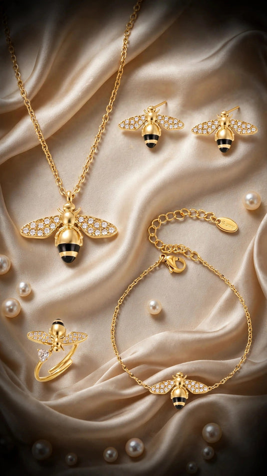 Abeja Dorada gold bee jewelry set — necklace, bracelet, earrings and ring on cream silk