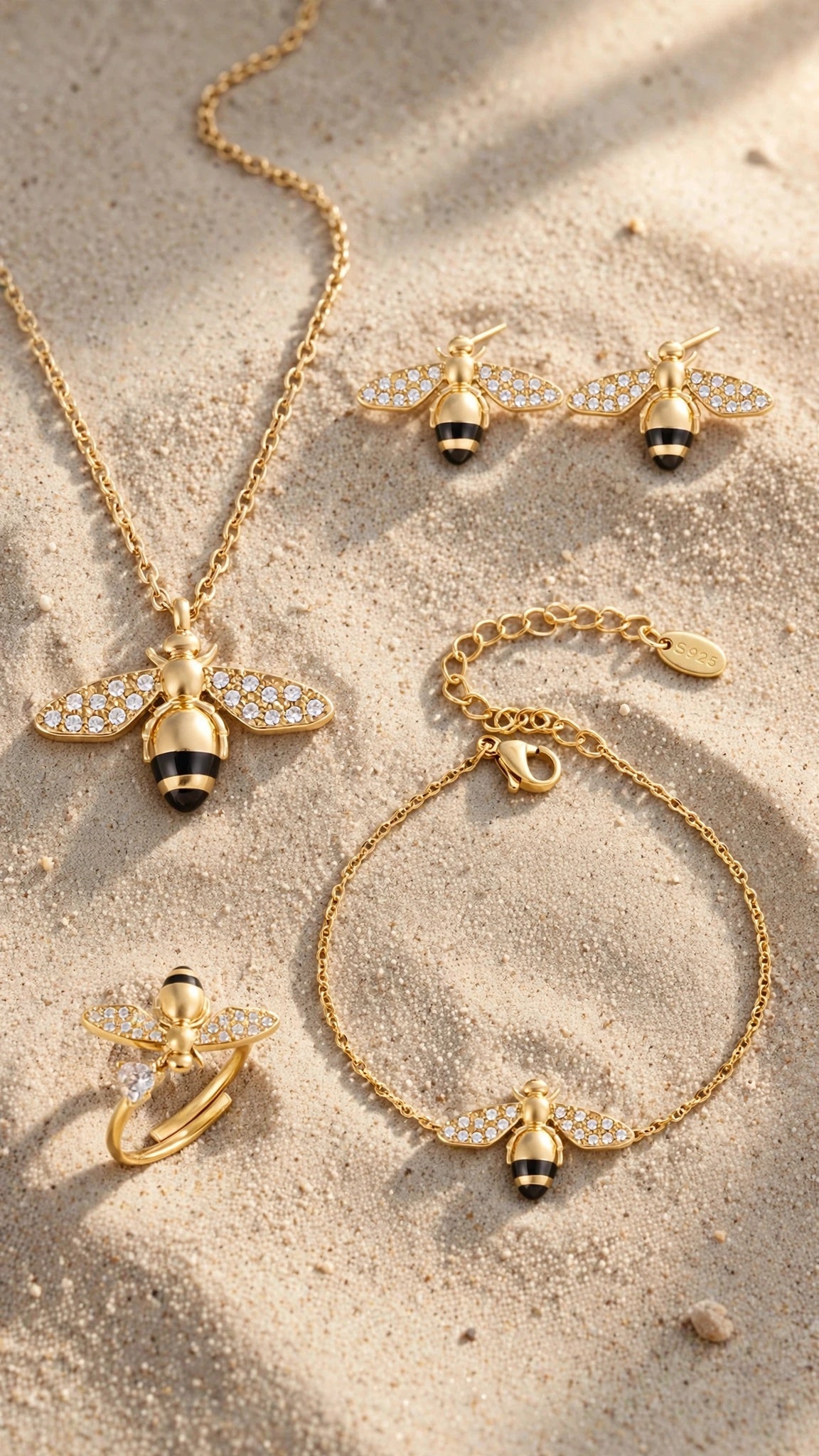 Abeja Dorada gold bee jewelry set styled on natural beach sand
